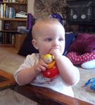 Annabel chewing on her wooden doll