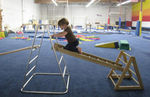 Trying out the obstacle course at E's gymnastics party