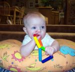 Annabel chewing on her wood triangles rattle