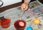 Carefully rolling the egg in dye
