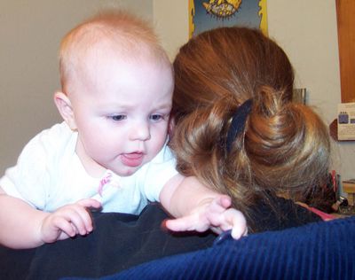 Trying to get the button on Mommy's coat (look at those matching locks!)