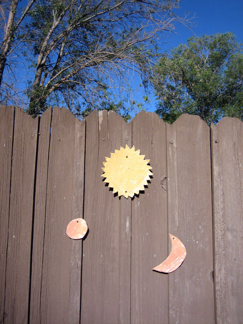 Annabel's contribution to our fence art. Fired & glazed pottery sun, moon & earth :)